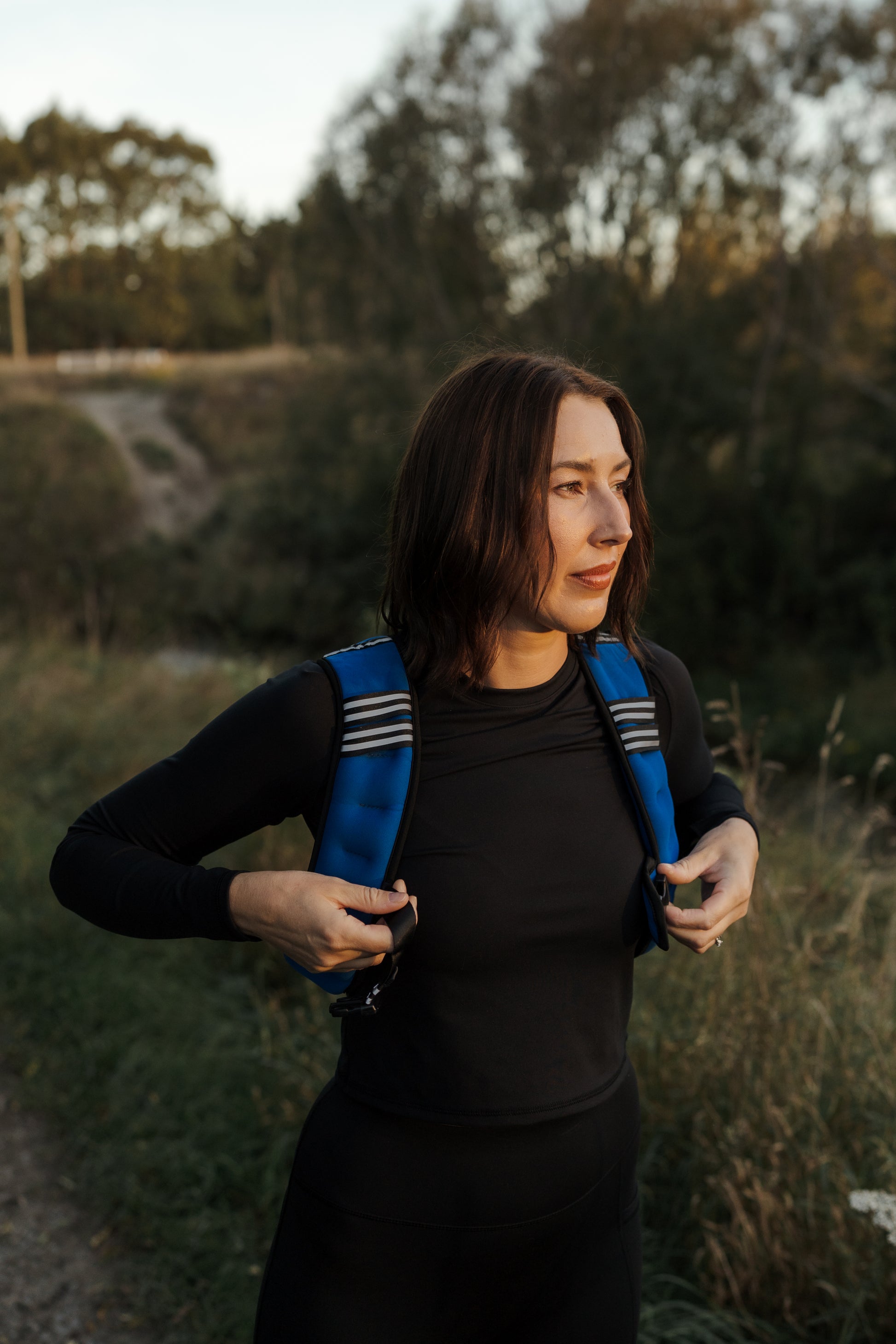 Lady putting on a blue VestFit NZ weighted vest